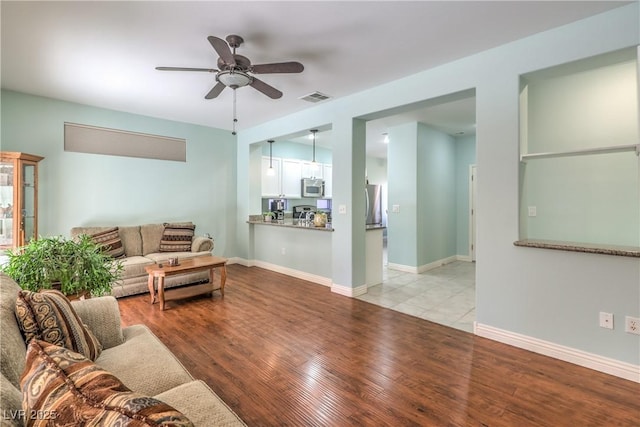 living room featuring light hardwood / wood-style flooring and ceiling fan