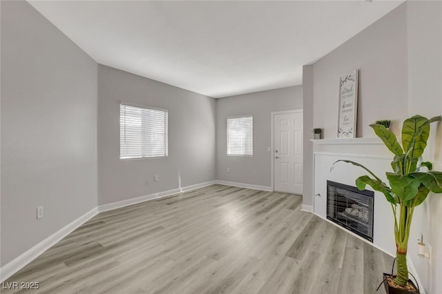 5250 S Rainbow Blvd Unit 2165, Las Vegas, NV 89118 - unfurnished living room featuring light wood-style floors and a glass covered fireplace