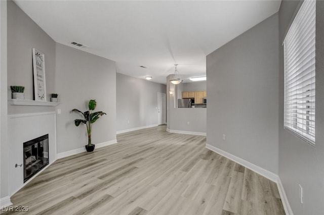 5250 S Rainbow Blvd Unit 2165, Las Vegas, NV 89118 - unfurnished living room featuring light wood-style flooring and a fireplace