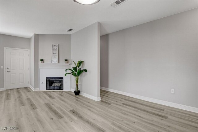 5250 S Rainbow Blvd Unit 2165, Las Vegas, NV 89118 - unfurnished living room with wood finished floors and a glass covered fireplace