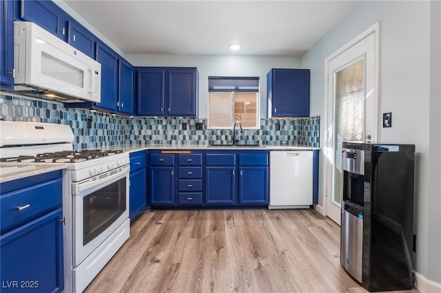 kitchen featuring blue cabinets, sink, light wood-type flooring, decorative backsplash, and white appliances