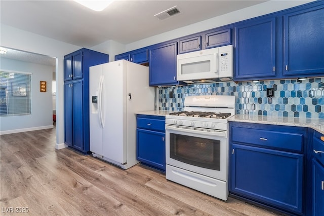 kitchen featuring white appliances, blue cabinetry, light stone counters, light hardwood / wood-style floors, and decorative backsplash