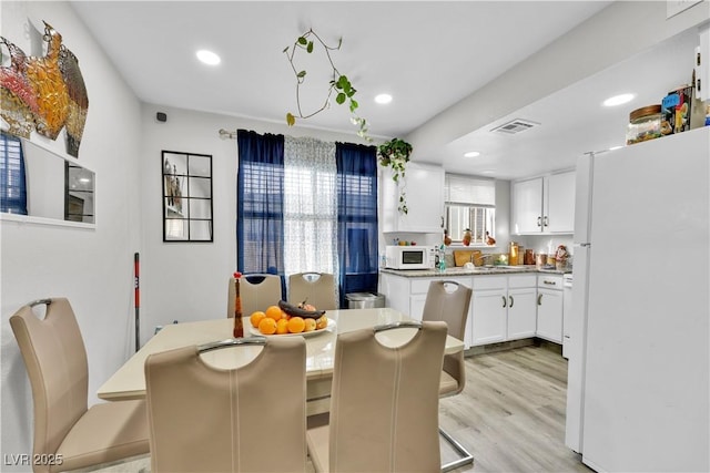 dining space with light hardwood / wood-style flooring