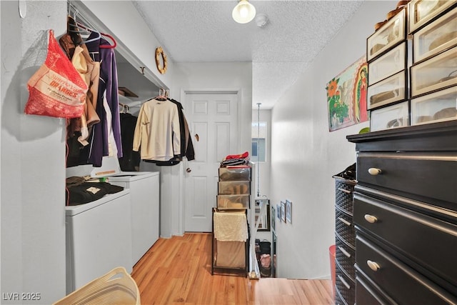 interior space featuring separate washer and dryer, light hardwood / wood-style floors, and a textured ceiling