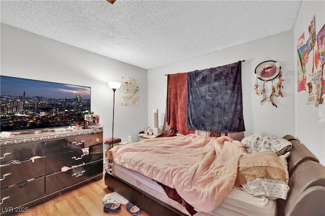 bedroom featuring hardwood / wood-style flooring and a textured ceiling