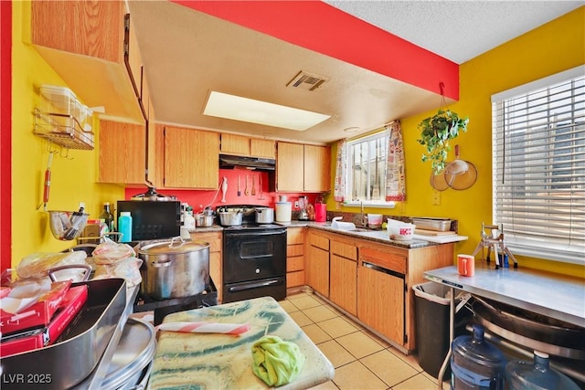 kitchen featuring light tile patterned flooring, a skylight, sink, black appliances, and a textured ceiling