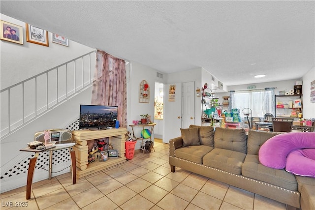 tiled living room featuring a textured ceiling