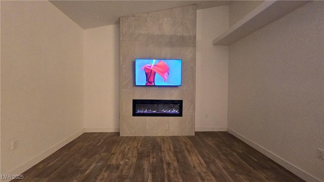 unfurnished living room featuring a fireplace, baseboards, and dark wood-style flooring