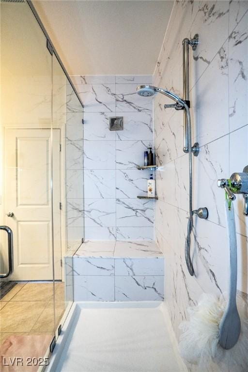 bathroom featuring a marble finish shower