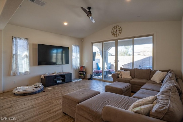 living room featuring ceiling fan, lofted ceiling, and light wood-type flooring