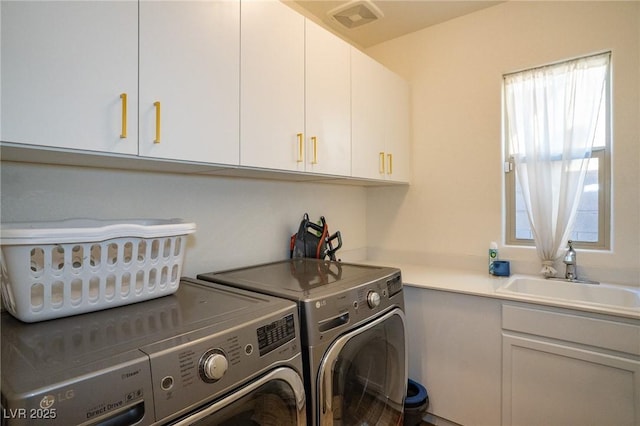 washroom with visible vents, independent washer and dryer, a sink, and cabinet space