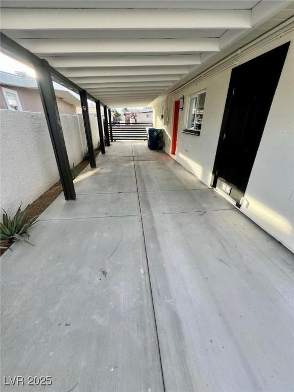 view of patio featuring a carport and fence