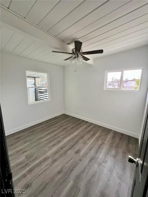 empty room with ceiling fan, dark wood-type flooring, wood ceiling, and baseboards