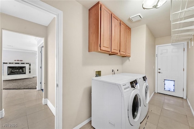 laundry room featuring cabinets, separate washer and dryer, and light tile patterned floors