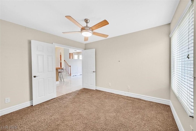 unfurnished bedroom with light colored carpet and ceiling fan