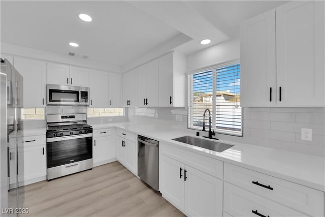 kitchen with white cabinetry, appliances with stainless steel finishes, and sink