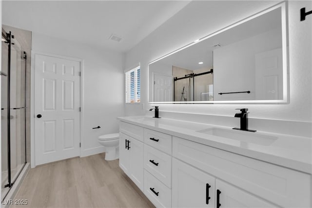 bathroom with vanity, hardwood / wood-style flooring, toilet, and walk in shower