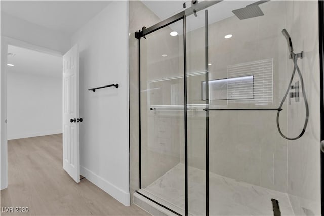 bathroom featuring an enclosed shower and hardwood / wood-style flooring