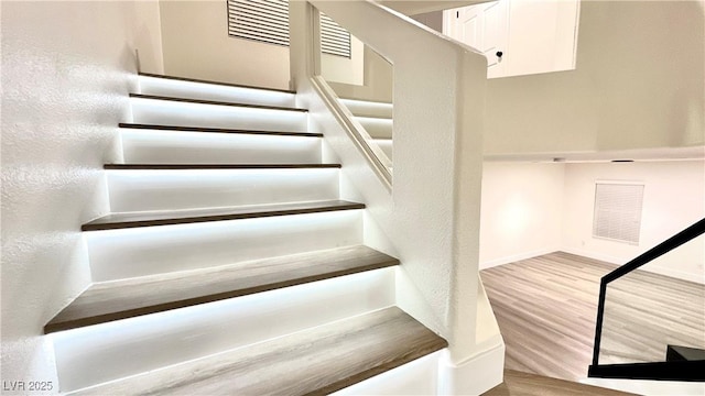 staircase with hardwood / wood-style flooring