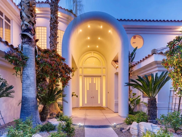 entrance to property featuring stucco siding