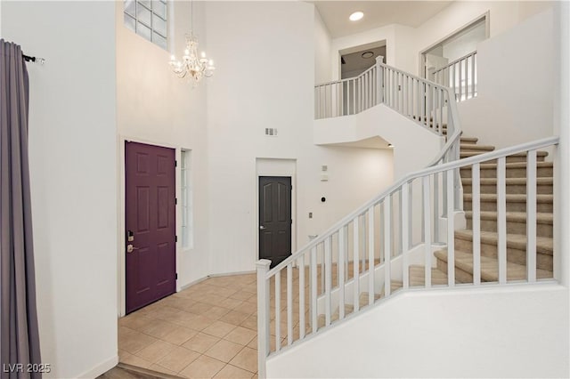 tiled foyer featuring a towering ceiling and a chandelier