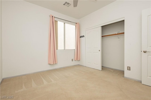 unfurnished bedroom featuring light carpet, a closet, and ceiling fan