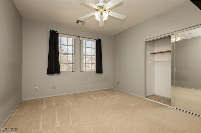 unfurnished bedroom featuring light carpet, ceiling fan, and a closet