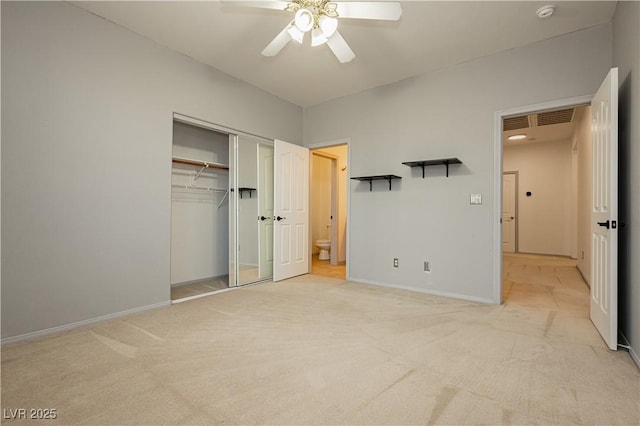 unfurnished bedroom with ceiling fan, a closet, connected bathroom, and light carpet