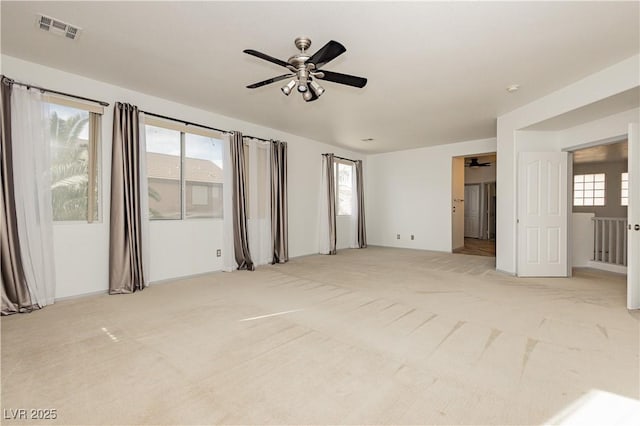 carpeted empty room with a healthy amount of sunlight and ceiling fan