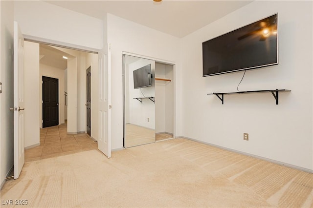 unfurnished bedroom with a closet and light carpet