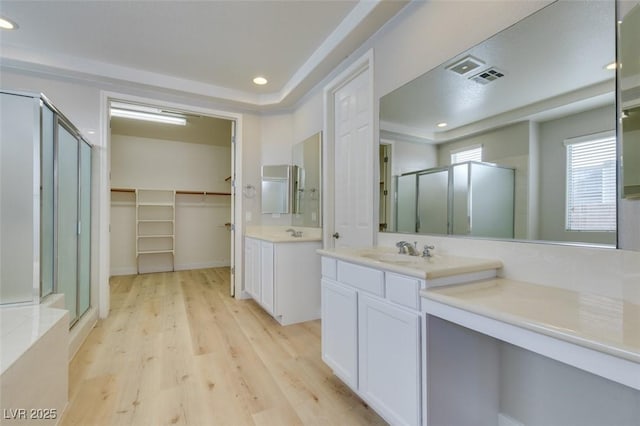 bathroom with hardwood / wood-style flooring, vanity, and a shower with shower door