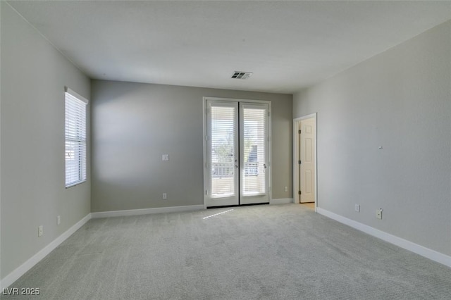 carpeted spare room with french doors