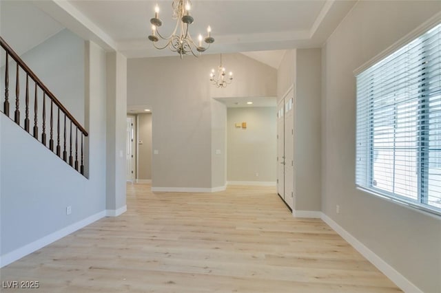 unfurnished dining area with a notable chandelier, light hardwood / wood-style flooring, and high vaulted ceiling