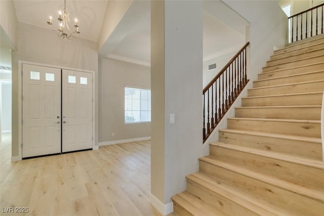 entrance foyer with a notable chandelier and light wood-type flooring