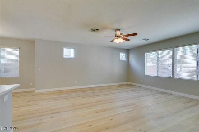 spare room with ceiling fan, light hardwood / wood-style floors, and a wealth of natural light