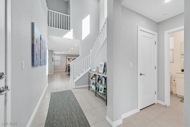 tiled entrance foyer featuring a towering ceiling