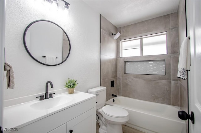 full bathroom with tiled shower / bath, vanity, and toilet