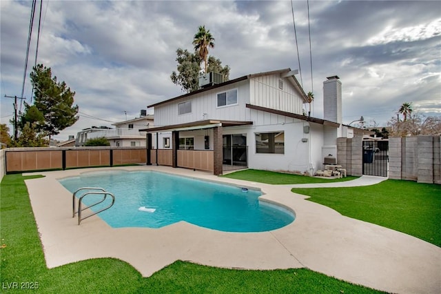 back of house with a fenced in pool, a lawn, and central air condition unit