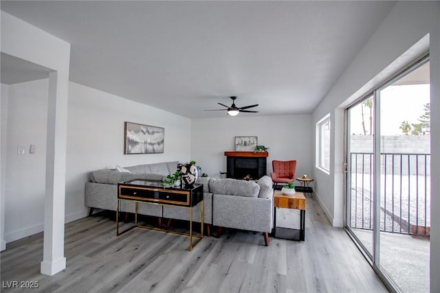 living room with light hardwood / wood-style flooring and ceiling fan