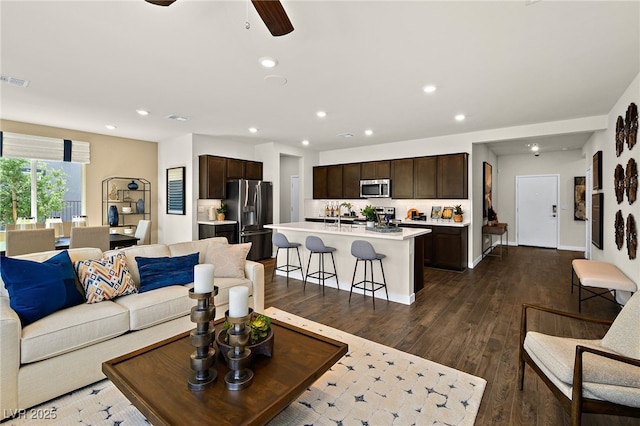 living room featuring dark hardwood / wood-style floors, sink, and ceiling fan