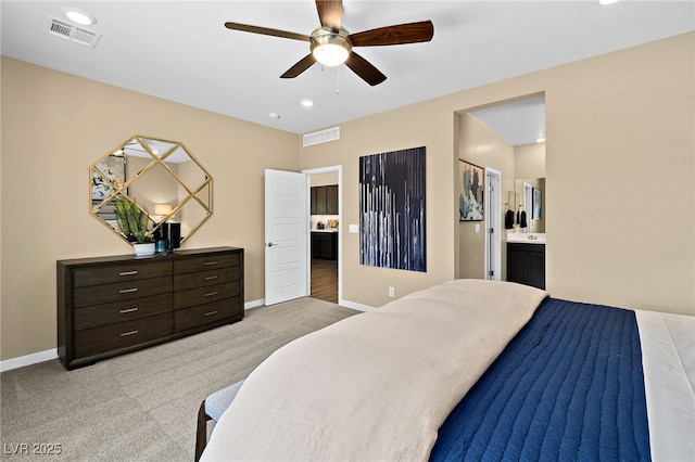 carpeted bedroom featuring ceiling fan and ensuite bath