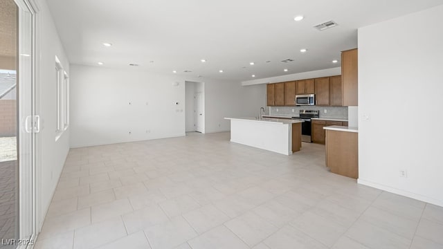 4485 E Brusca Way, Pahrump, NV 89061 - kitchen with stainless steel appliances, a sink, open floor plan, brown cabinets, and light countertops