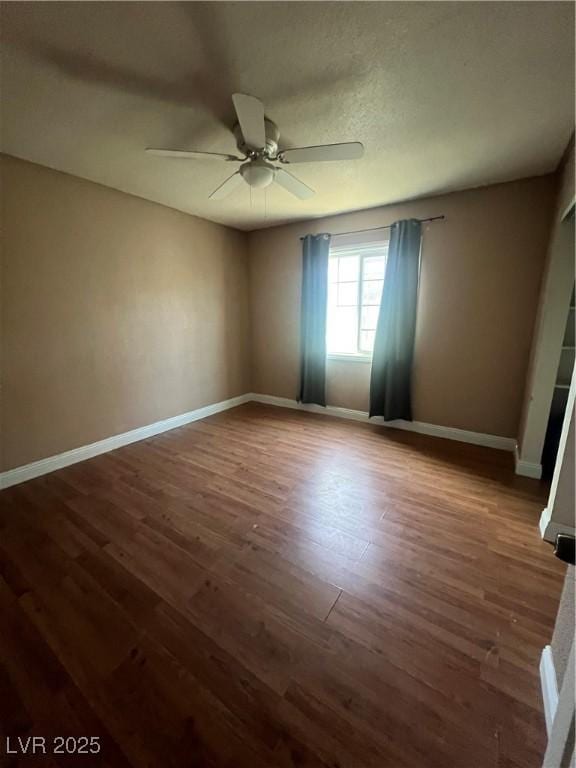 unfurnished room with dark hardwood / wood-style floors and ceiling fan