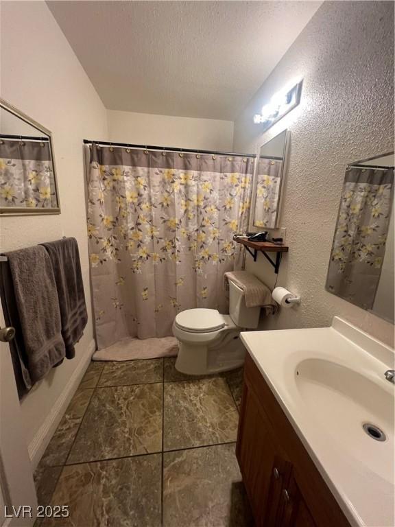 bathroom with a shower with curtain, vanity, toilet, and a textured ceiling