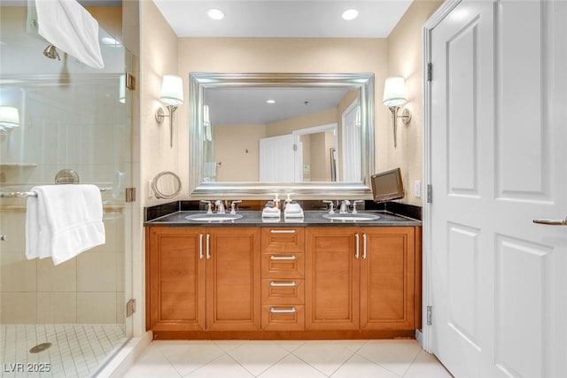 full bath with a stall shower, double vanity, and tile patterned flooring