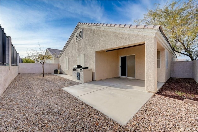 back of property with central AC and a patio area