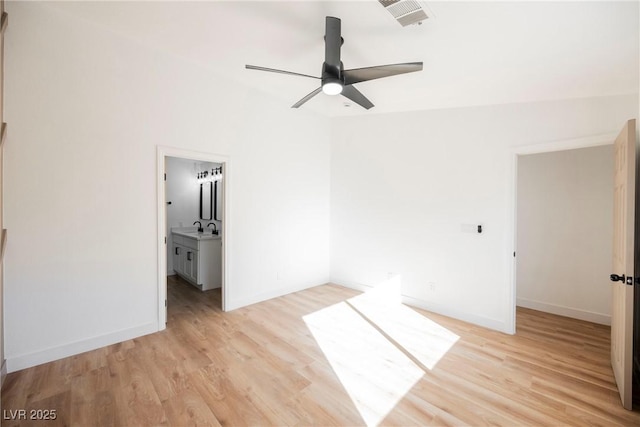 unfurnished bedroom featuring connected bathroom, sink, light hardwood / wood-style flooring, and ceiling fan