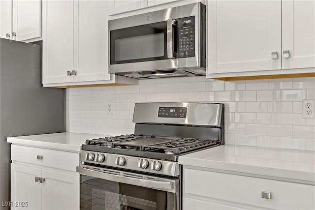 kitchen featuring decorative backsplash, stainless steel appliances, and white cabinets