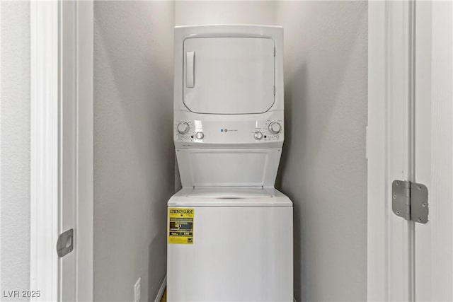 washroom featuring stacked washer and clothes dryer