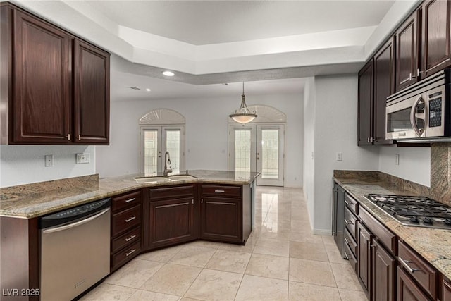 kitchen with sink, stainless steel appliances, a raised ceiling, french doors, and kitchen peninsula